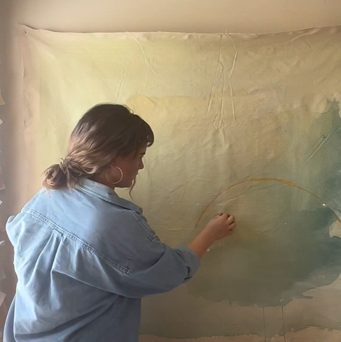 Person painting on a large canvas